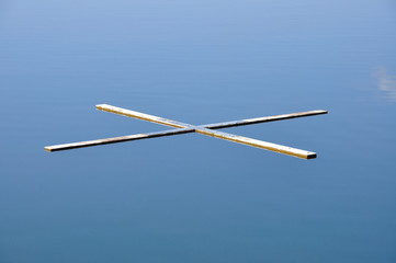 Holzkreuz im See