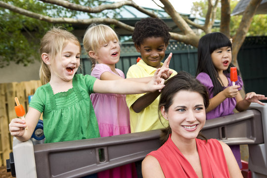 Young preschool children playing in daycare with teacher