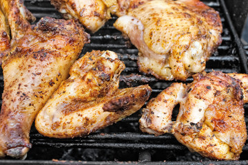 Closeup of chicken meat on barbecue grill with selective focus