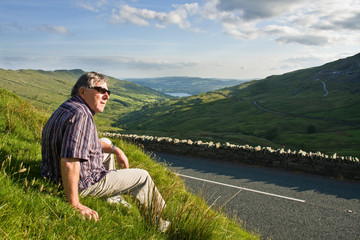 Retired man resting near the road