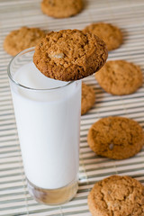 glass of fresh milk and oat cookies on the table