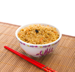 Bowl of cooked rice with chopsticks on bamboo napkin