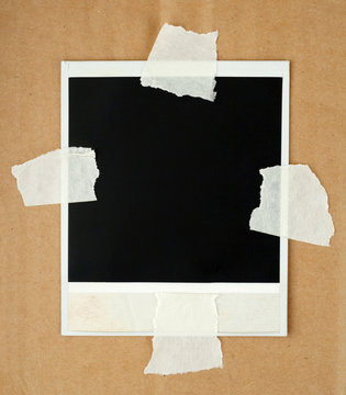 Blank photo card with masking tape on a cardboard