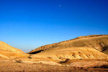 Fototapeta na wymiar Duży krater na pustyni Negev z księżyca na niebie.