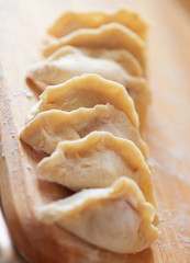 Raw ravioli on wooden plank