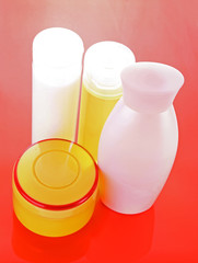 Pink bottles of shampoo  on the red background