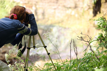 Female photographer taking a picture using tripod