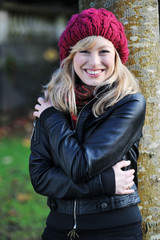 Happy Young Woman Leaning Against A Tree