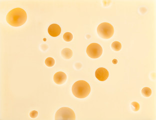 Cheese background with heart shape holes