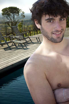 Jeune homme en vacances au bord d'une piscine