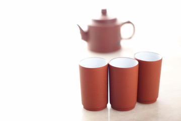 Chinese teapot with teacups set on marble table