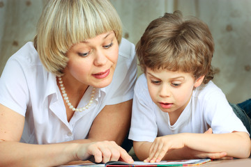 woman and little boy reading book