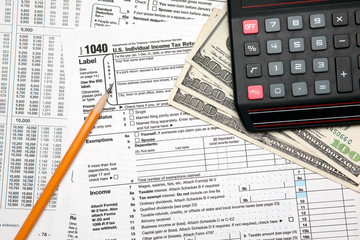 Tax time - U.S. 1040 tax return with pencil and calculator