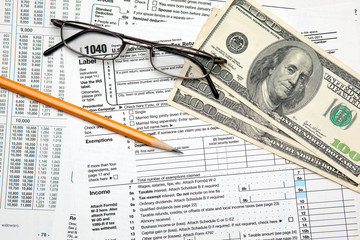 Tax time - Closeup of U.S. 1040 tax return with pencil and glass