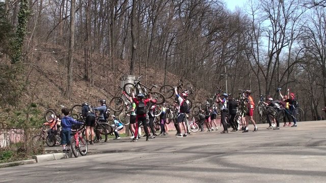 Mountain bikers celebrate victory by holding bikes over heads