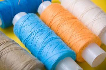 Fototapeta na wymiar blue, orange, white and brown spools of thread