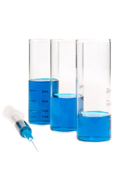 tubes and syringe with blue liquid on a white background
