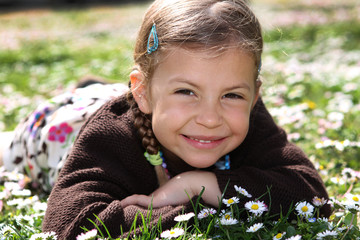 Young girl enjoys lying amongst daisies in a meadow © wazymodo