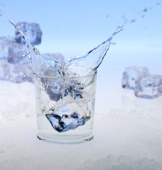 Eiswürfel fallen in ein Glas