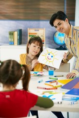 Schoolgirl showing painting in art class