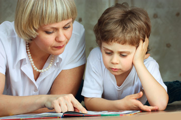 woman and little boy reading book