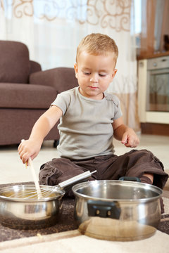 Little boy playing withcooking pots