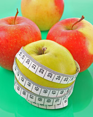 White tape measure around a red apple representing dieting