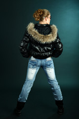 Girl in blue jeans and black jacket rear view