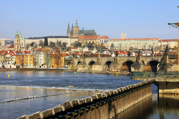 The snowy colorful Prague gothic Castle with the Charles Bridge