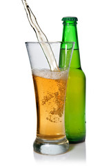 Beer pouring from into glass isolated with bottle on white