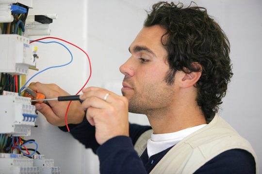 Portrait d'un &eacute;lectricien travaillant sur un compteur &eacute;lectrique