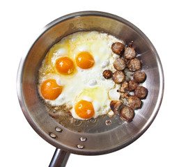 Frying pan with sausage slices and eggs