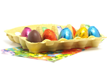 chocolate easter eggs in carton box over white background