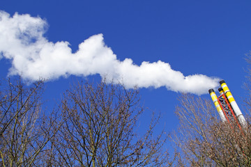 Chimney emitting smoke against a blue sky