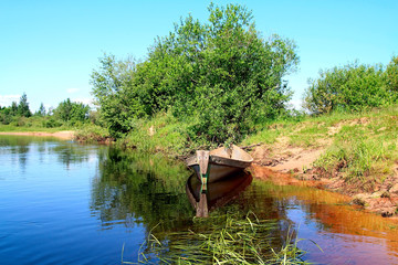 aging boat on coast river.