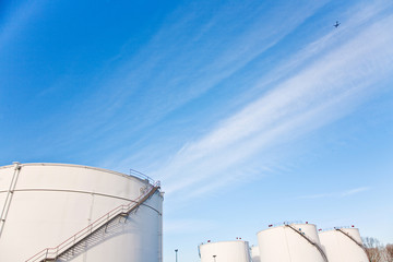 white tanks for petrol and oil in tank farm with blue sky