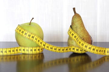 Measuring tape, apple and pear