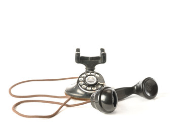 An antique telephone with handset off the hook