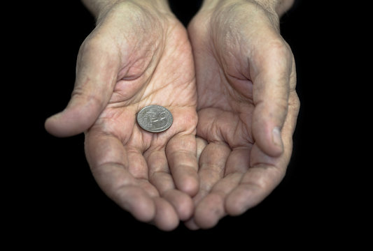 Poverty. Old hands with a single coin of 25 cents