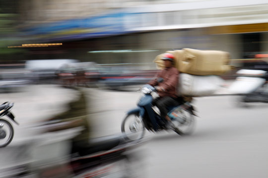 vollbeladenes Motorrad in Hanoi Vietnam mit Bewegungsunschärfe