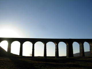 Viaduct silhouette against blue sky