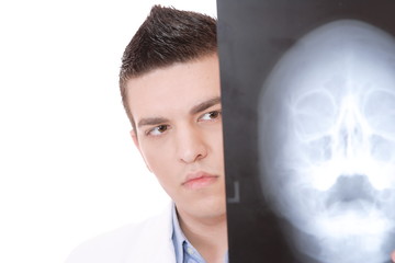 Caucasian mid adult male doctor holding up xrays.