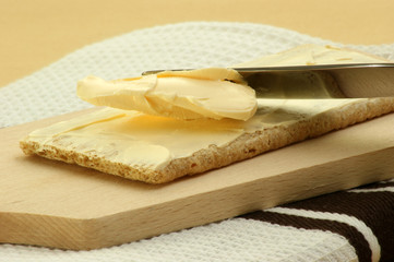 Knäckebrot wird mit Butter bestrichen