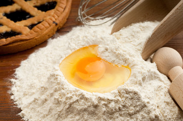 Fototapeta na wymiar flour with egg and cake on background