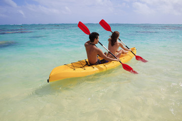 young couple kayaking in hawaii