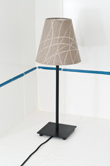 Electric table lamp on white tile background
