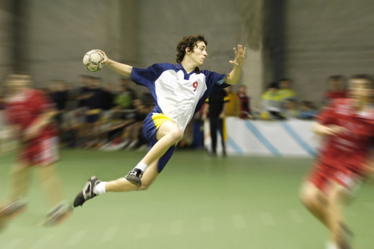 young handball player on a match jumping to score a goal
