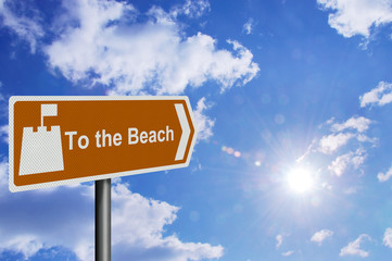 photo realistic 'to the beach' sign, against a sunny blue sky