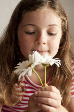 Little Girl Smelling Daisies