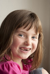 little girl smiling through missing front teeth